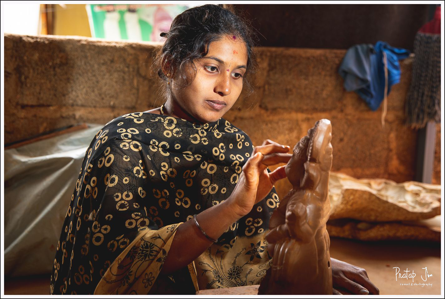 Portrait of a woman shaping a Ganesha idol by hand